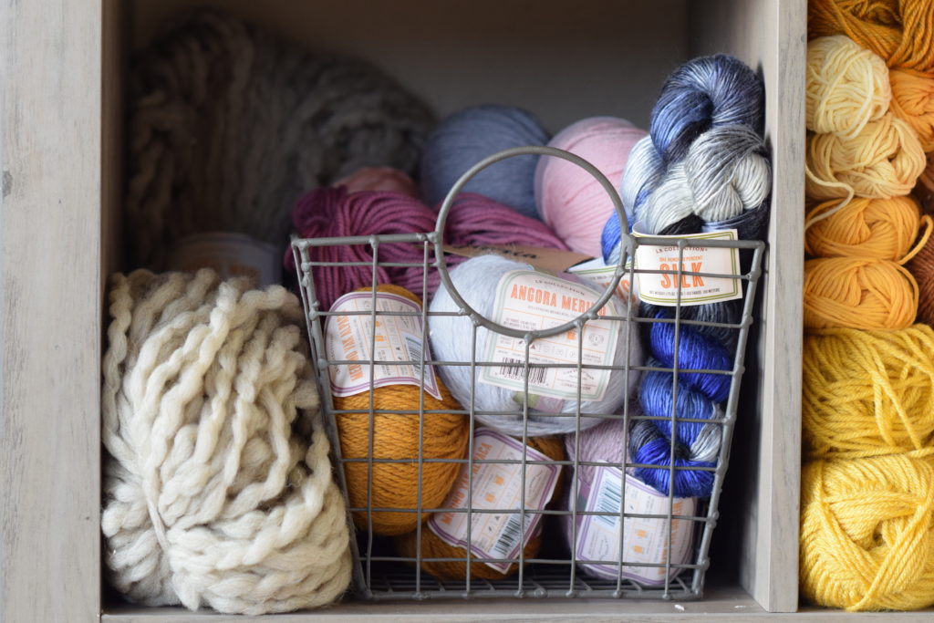 Neatly arranged colorful yarn and crochet hooks in a basket on Craiyon